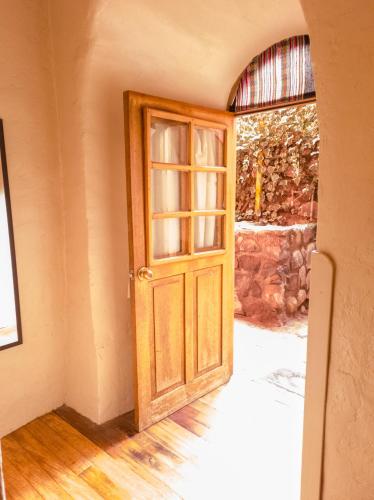an open wooden door in a room with a window at Loki Cusco in Cusco