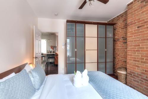 a bedroom with a white bed with a brick wall at Fox Aparthotel Palais Des Congres VI in Montréal