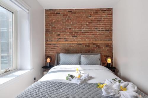 a bedroom with a bed and a brick wall at Fox Aparthotel Palais Des Congres VI in Montréal