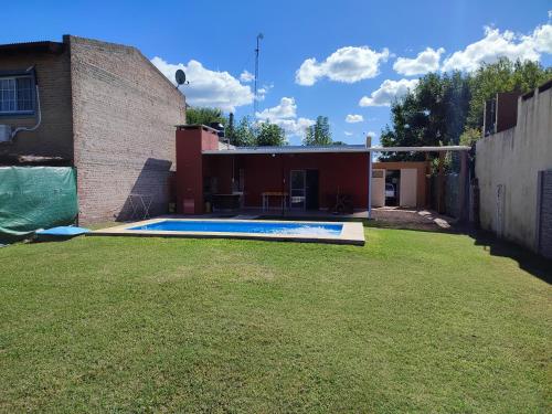 een achtertuin met een zwembad en een gebouw bij Casa quinta La Ruchi in San Andrés de Giles