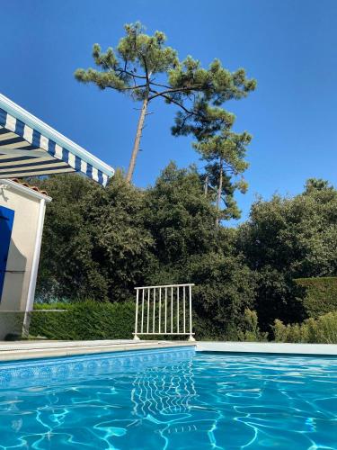 une piscine avec un arbre en arrière-plan dans l'établissement Coastal bliss, à Grand-Village-Plage