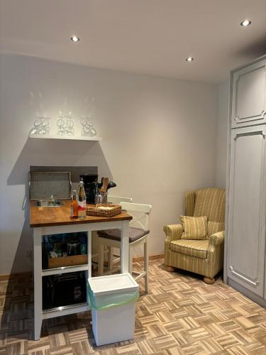 a kitchen with a counter and a table and a chair at Ferienapartments Engeln Eifel in Kempenich