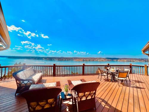 a deck with chairs and tables and a view of the water at The Overlook At Cedar Point in Osage Beach