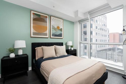 a bedroom with a bed and a large window at 2BR 2BA Suite with Sofa Bed by Financial District in Toronto