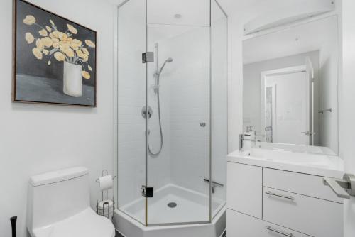 a bathroom with a shower and a toilet and a sink at 2BR 2BA Suite with Sofa Bed by Financial District in Toronto