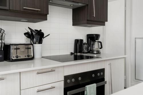 a kitchen with a counter top with a stove top oven at 2BR 2BA Suite with Sofa Bed by Financial District in Toronto