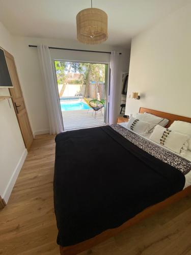 - une chambre avec un grand lit et une porte coulissante en verre dans l'établissement Maison Pierre avec Piscine, à Bordeaux