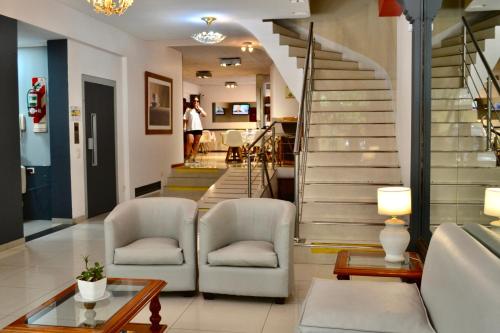 a living room with two chairs and a staircase at Alpino Hotel in Buenos Aires