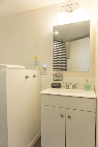 a white bathroom with a sink and a refrigerator at Modern lofty studio in Midtown / Charming Old SW in Reno