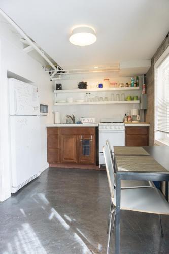 a kitchen with a table and a white refrigerator at Modern lofty studio in Midtown / Charming Old SW in Reno