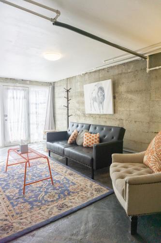 a living room with a couch and a table at Modern lofty studio in Midtown / Charming Old SW in Reno