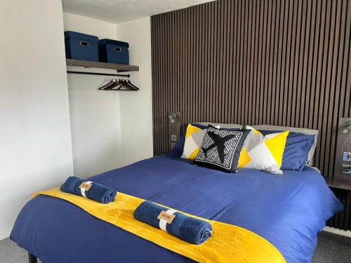 a bedroom with a bed with blue sheets and pillows at AeroSuites Luton - SHARED AND PRIVATE Accommodations mins from Luton Airport,FREE selected Breakfast,Adults Only,FREE Parking subject to availability and reservation only, Whats Up number required, Late Self Check In and Out by request only in Luton