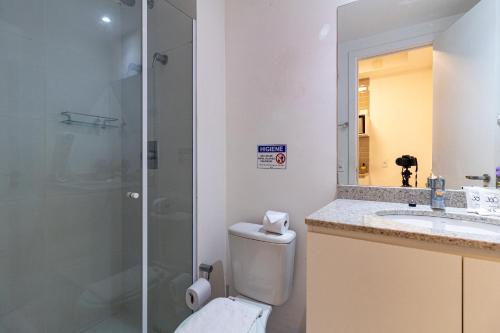 a bathroom with a shower and a toilet and a sink at 360 Suítes Sé in Sao Paulo