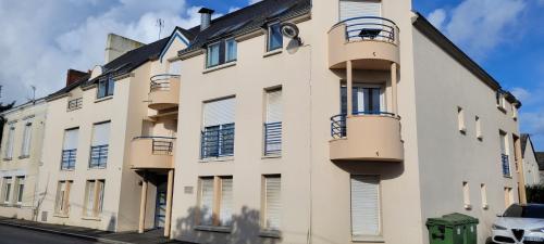 un bâtiment blanc avec des balcons sur le côté dans l'établissement Studio Blain centre ville, à Blain