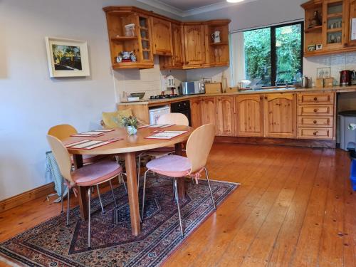 a kitchen with a wooden table and chairs at Glendalough Sanctuary in Brockagh