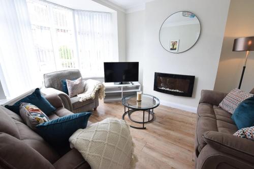 a living room with two couches and a tv at Maggies Leap Townhouse in Newcastle