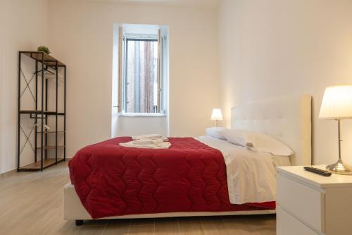 a bedroom with a large bed with a red blanket at Relais Palazzo Nizza - Luxotel & Apartotel in Salerno