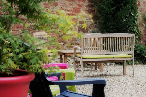 un banc en bois et une table dans un jardin dans l'établissement Gite Ophelia dans Domaine Viticole - Maison ZEYSSOLFF, à Gertwiller