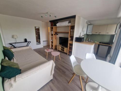 un salon avec un lit, une table et des chaises dans l'établissement TypeT1 Spacieux à 300m du port et 6min de la plage, à La Grande Motte