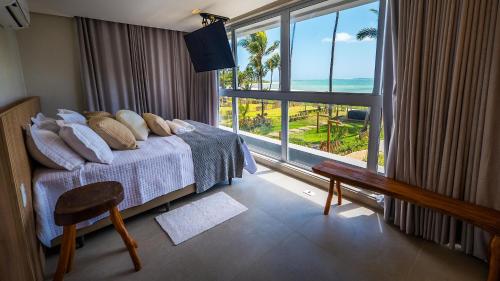 een slaapkamer met een bed met uitzicht op de oceaan bij Casa de luxo pé na areia na Praia Marceneiro em Milagres in São Miguel dos Milagres