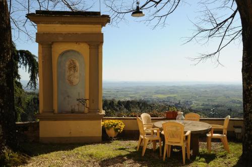 a table and chairs with a view of the countryside at Agriturismo La Gioconda in Vinci