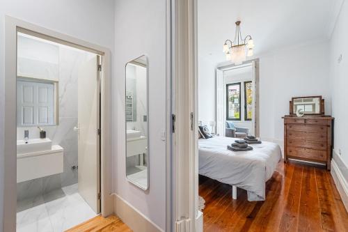a bedroom with a bed and a sink and a mirror at Hidden Gem near city center- garden, outdoor kitchen, sauna in Porto