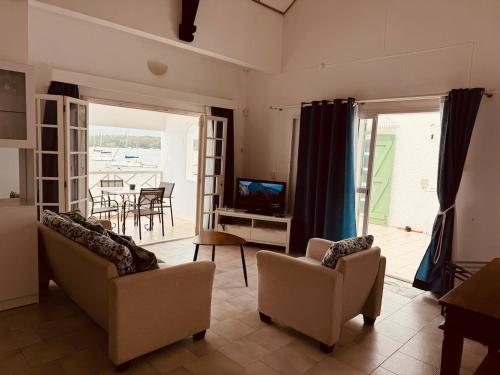a living room with two couches and a television at Dan Beach Apartment in Trou dʼ Eau Douce