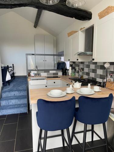 a kitchen with a table and two blue chairs at No1 The Smithy in Chester