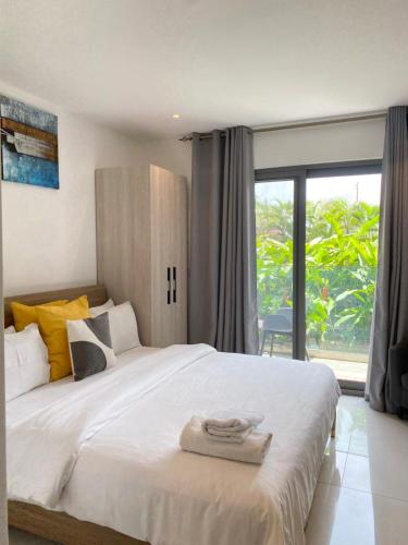 ein Schlafzimmer mit großem Bett und großem Fenster in der Unterkunft Serene Space at the Lennox in Accra
