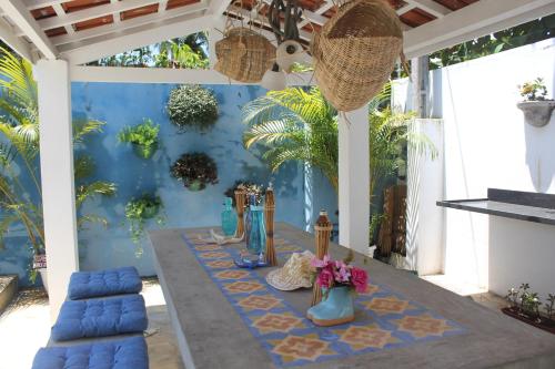 a table in a room with a blue wall at Canto das Laranjeiras Villa in Guarujá
