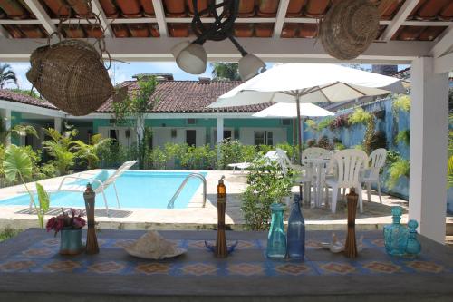 a table with bottles on it next to a pool at Canto das Laranjeiras Villa in Guarujá