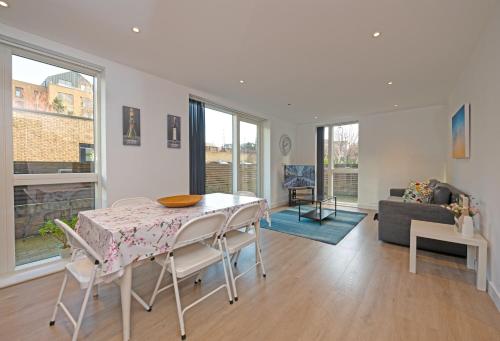 a living room with a table and chairs and a couch at Grand Apartments Kew Gardens in London