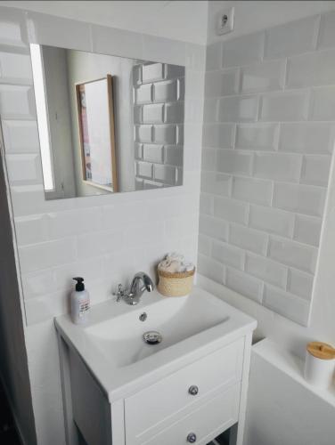 une salle de bain blanche avec un lavabo et un miroir dans l'établissement Les baigneuses à COLLIOURE, à Collioure
