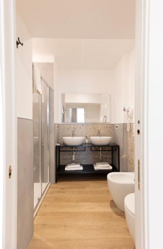 a bathroom with two sinks and two mirrors at Tiburtina 86 Luxury Suites in Rome