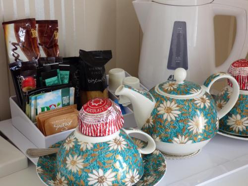 a counter with two vases and a tea pot on it at Douglas Park Guest House in Dunoon