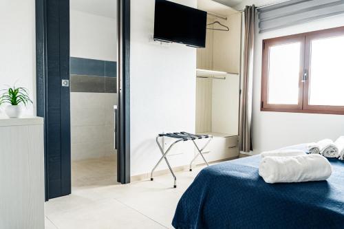 a bedroom with a bed and a shower and a television at Il Porticciolo in La Caletta