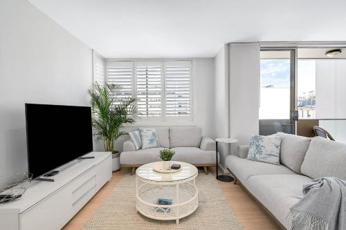 a living room with a couch and a tv at Heart of Manly - Quiet 1 Bed between Beach & Harbour in Sydney