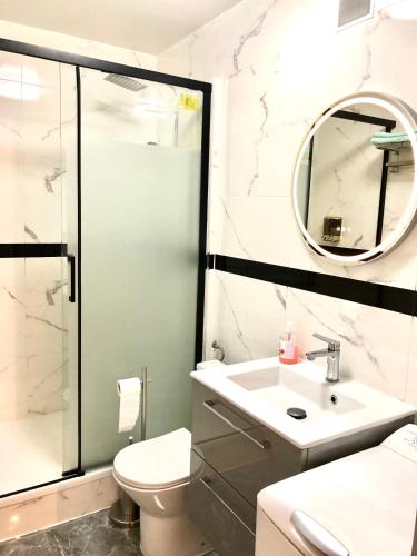 une salle de bain avec toilettes, lavabo et miroir dans l'établissement Appartement entier HUI, à Rueil-Malmaison