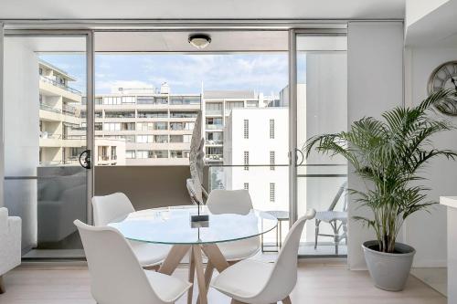 a dining room with a table and chairs and a large window at Heart of Manly - Quiet 1 Bed between Beach & Harbour in Sydney