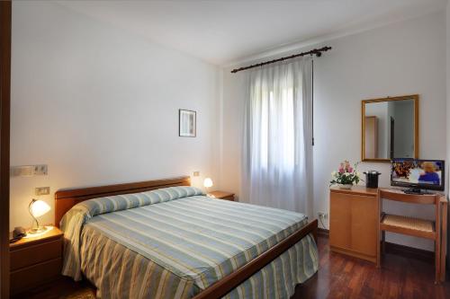 a bedroom with a bed and a desk and a mirror at Albergo Volpara in Mussolente 