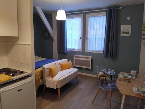 Cette petite chambre dispose d'un canapé, d'une table et d'une cuisine. dans l'établissement Studio Mer et Centre équestre, à Mers-les-Bains