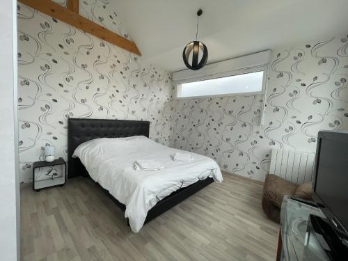a bedroom with a bed with white sheets and a wall at Modern and Bright home walk to beach with garage in Berck-sur-Mer