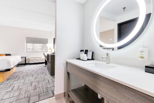 a bathroom with a sink and a large mirror at La Quinta Inn & Suites by Wyndham Jacksonville Mandarin in Jacksonville