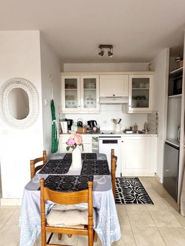 une cuisine avec une table avec un vase dessus dans l'établissement à 10 minutes à pieds de la plage, Résidence La Corniche du Mont Canisy - Traveller Award 2023, à Blonville-sur-Mer