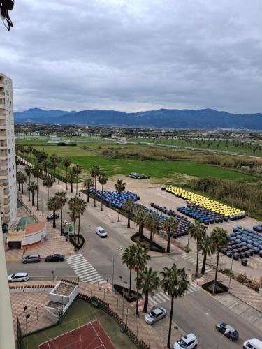 ein Parkplatz mit Palmen und geparkten Autos in der Unterkunft Arensol Playa de Cullera in Cullera