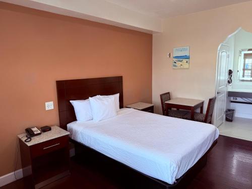 a hotel room with a bed and a chair at Travelodge by Wyndham Harbor City in Harbor City