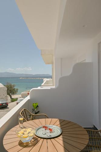 a wooden table on a balcony with a view of the ocean at Flèria Seaview Suites in Naxos Chora