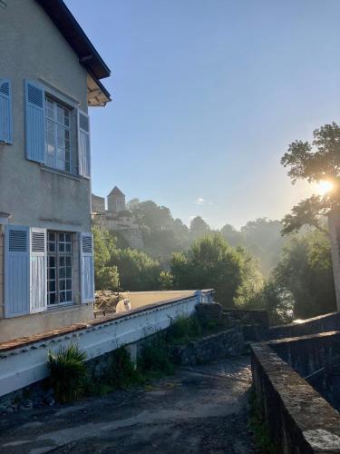a building with the sun setting in the background at Maison du Gave in Sauveterre