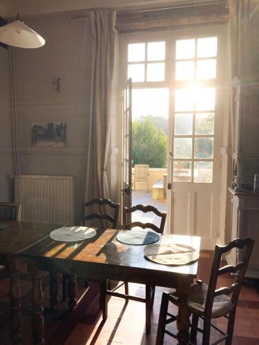 a dining room with a table and chairs and a window at Maison du Gave in Sauveterre