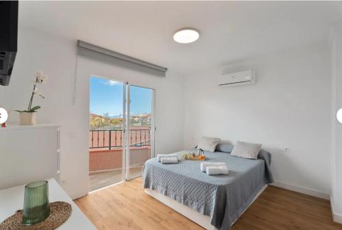 a white bedroom with a bed and a large window at Villa TEJINA BEAUTIFUL in Guía de Isora